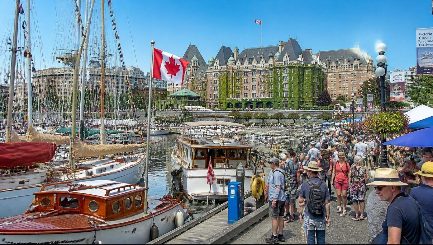 Classic boats on display at the Victoria Inner Harbour boat show, with heritage vessels and the Empress Hotel in the background
